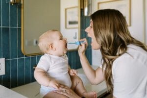 Moeder die de tandjes poetst van haar baby